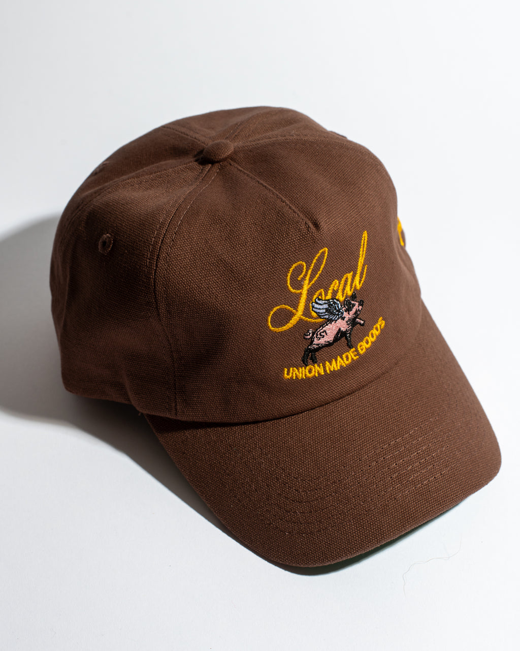 Brown cap with yellow embroidery on a white background