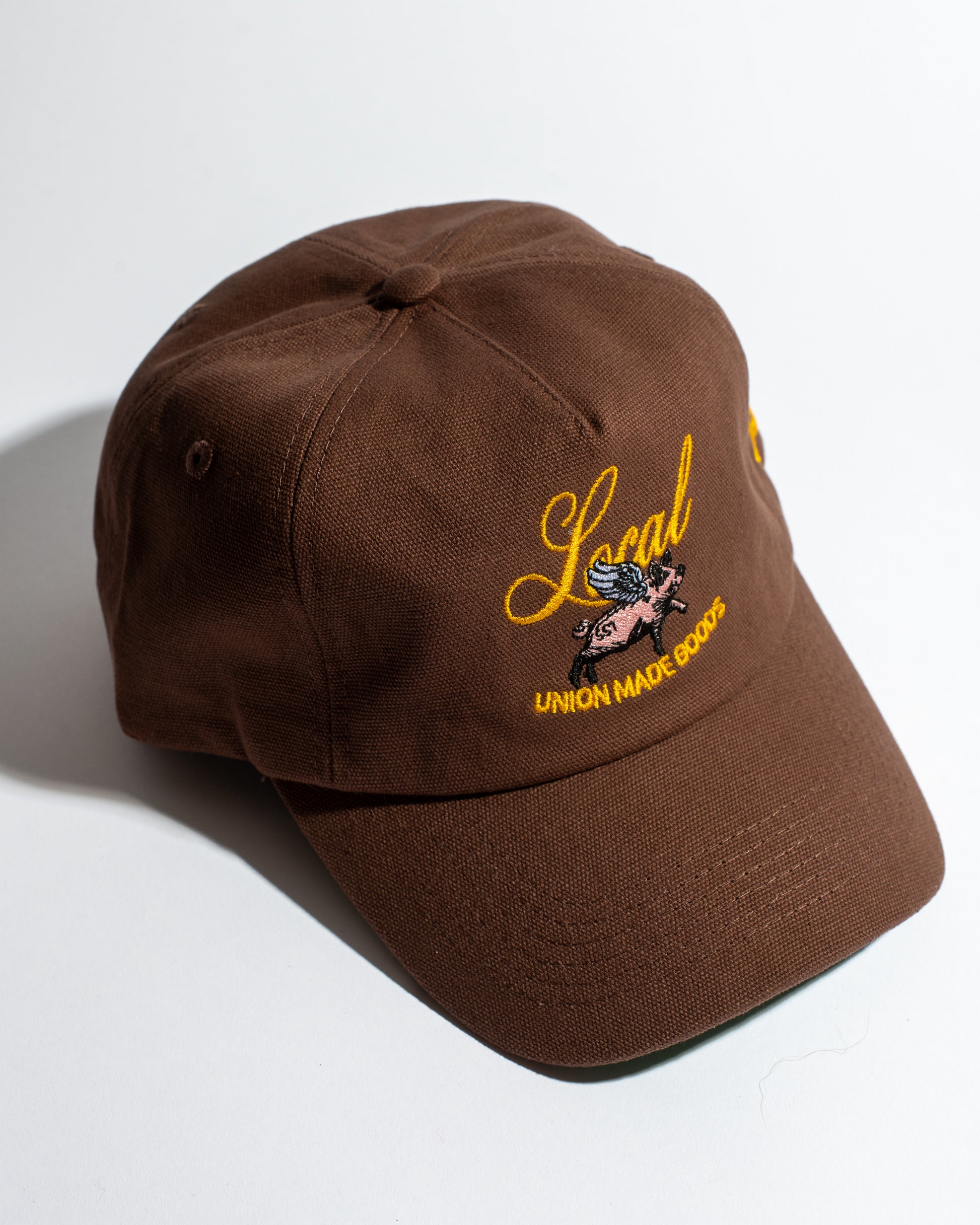 Brown cap with yellow embroidery on a white background