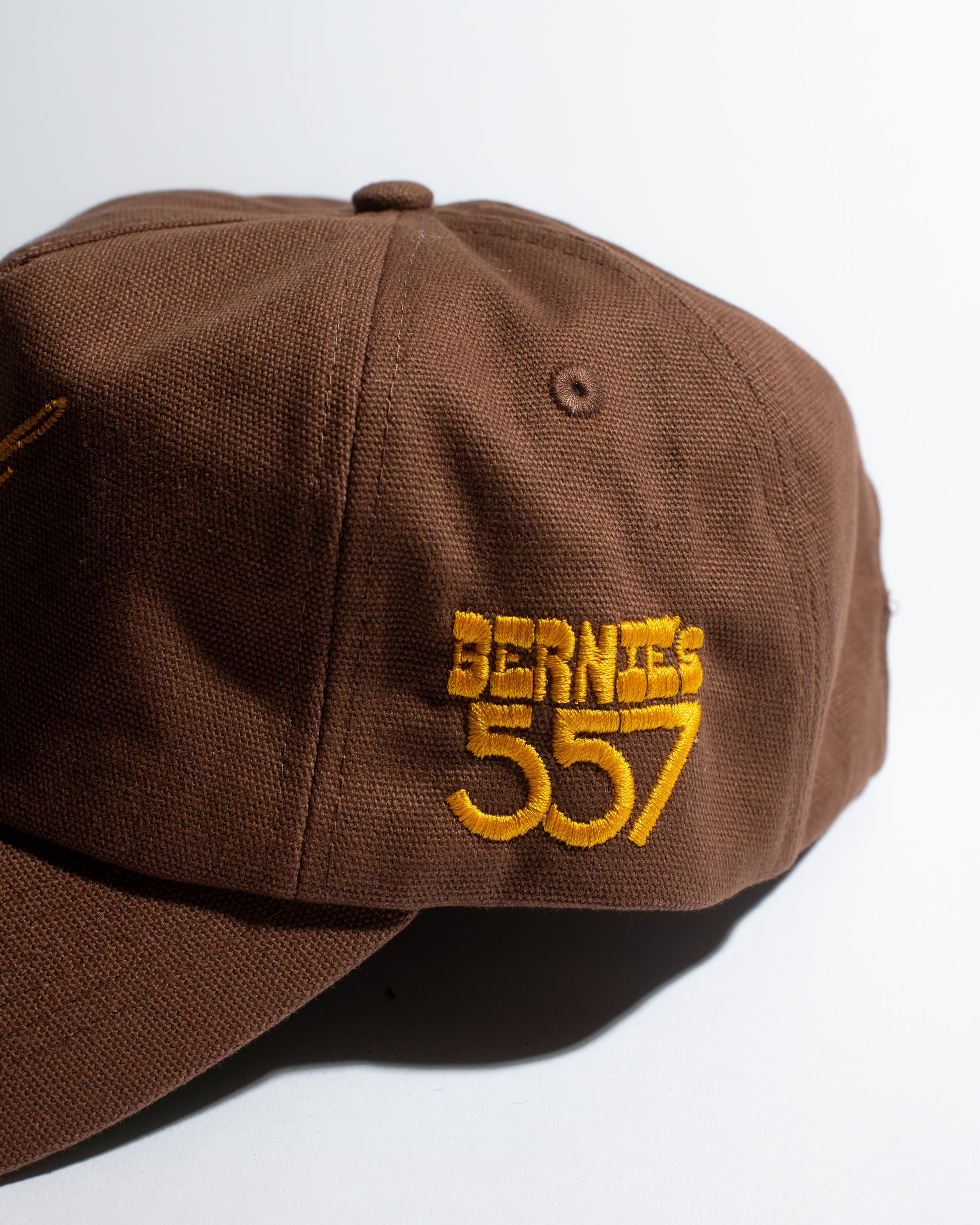 Brown cap with yellow text 'Bernie's 557' on a white background