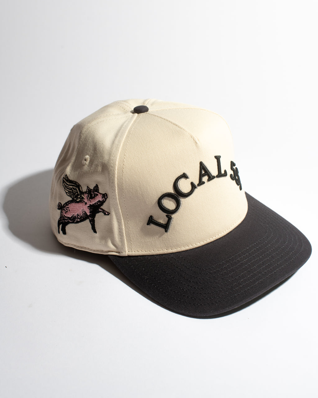 Beige and navy cap with 'LOCAL' and pig graphic on a white background