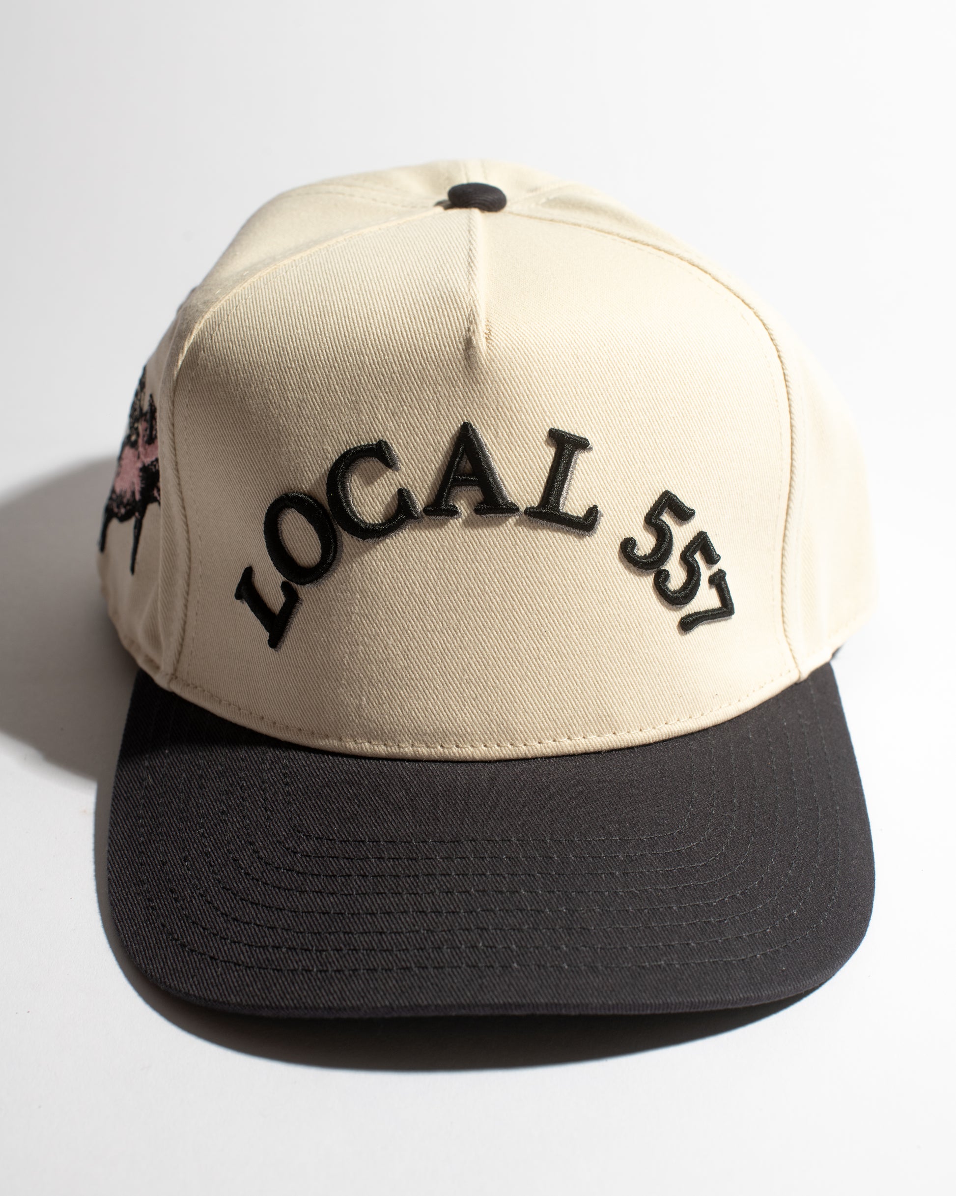 Beige and navy cap with 'LOCAL 557' text on a white background