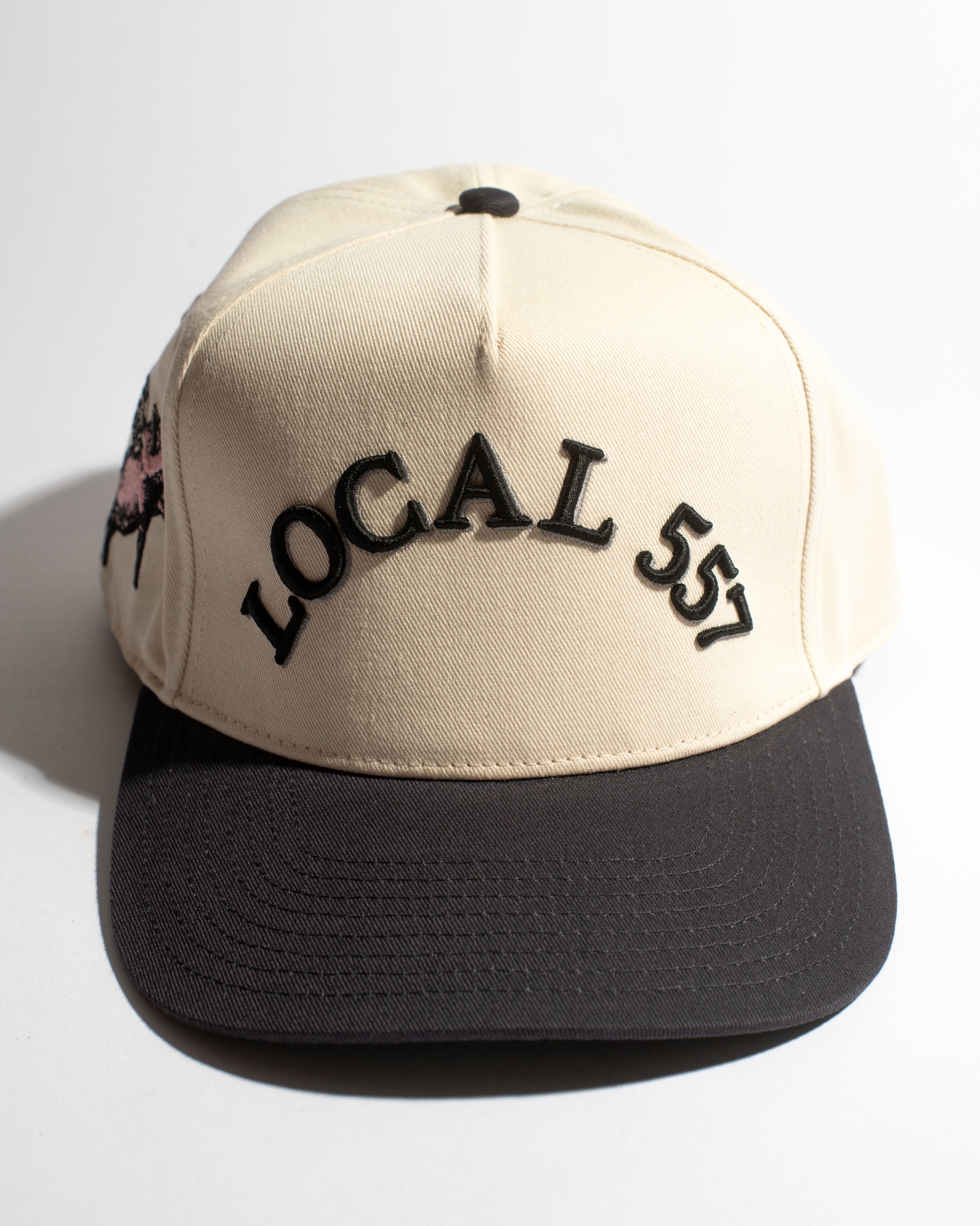 Beige and navy cap with 'LOCAL 557' text on a white background